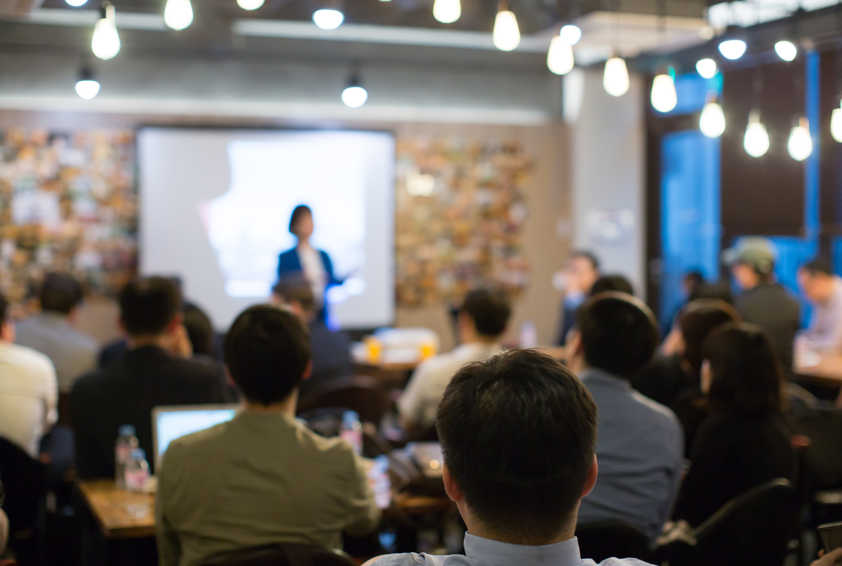 Audience Watching a Presentation. Defocused Blurred Presenter During Conference Meeting